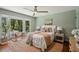 Serene bedroom featuring a large bay window with wooded views, a ceiling fan, and a cozy rug at 338 Mcclellan Ave, McClellanville, SC 29458