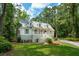 Beautiful two-story home with a inviting porch and a lush green lawn surrounded by trees at 338 Mcclellan Ave, McClellanville, SC 29458