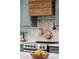 Kitchen features a wood stove hood and copper cookware hung above a range at 338 Mcclellan Ave, McClellanville, SC 29458