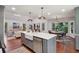 Bright kitchen featuring a large island, farmhouse sink, and stainless steel appliances, adjacent to the dining and living areas at 338 Mcclellan Ave, McClellanville, SC 29458
