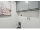 Laundry room features grey cabinets with modern brass hardware and coastal artwork on the wall at 338 Mcclellan Ave, McClellanville, SC 29458