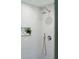 Elegant shower features white tiled walls, rainfall showerhead, and convenient inset shelving for toiletries at 338 Mcclellan Ave, McClellanville, SC 29458