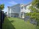 This backyard features a well-maintained lawn, mulch beds, and a view of the porch with outdoor seating at 360 Parish Farms Dr, Summerville, SC 29486