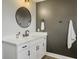 Well-lit bathroom featuring a white vanity, modern fixtures, mirror, and stylish towel hooks on gray accent wall at 360 Parish Farms Dr, Summerville, SC 29486