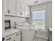 Well-lit laundry room with white cabinets, counter space, and modern washer and dryer at 360 Parish Farms Dr, Summerville, SC 29486
