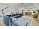 Open-concept living area with hardwood floors, blue sectional sofa, kitchen and adjacent staircase at 360 Parish Farms Dr, Summerville, SC 29486