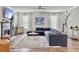Comfortable living room with hardwood floors, fireplace, large windows, and blue sectional sofa at 360 Parish Farms Dr, Summerville, SC 29486