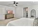 Bright primary bedroom featuring a ceiling fan, dresser, and a doorway to an ensuite bathroom at 360 Parish Farms Dr, Summerville, SC 29486