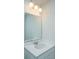 Close-up of bathroom with white countertop and backsplash, rectangular mirror and modern lighting fixture at 3745 Sawmill Ct, Mount Pleasant, SC 29429