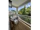 Relaxing outdoor balcony with seating, views of lush greenery, and a glimpse of nearby buildings at 400 Bucksley Ln # 301, Charleston, SC 29492