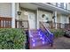 Home with wooden front steps lit with bright blue lights and a landscaped yard at 4765 Arco Ln, North Charleston, SC 29418