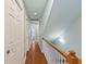 Bright hallway with hardwood floors and fresh paint, leading to bedrooms and living spaces at 4765 Arco Ln, North Charleston, SC 29418