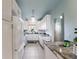 Bright galley kitchen boasts white cabinets and stainless appliances for a modern feel at 4765 Arco Ln, North Charleston, SC 29418