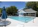 Community pool area featuring lounge chairs, umbrellas, and adjacent clubhouse at 507 Stinson Dr # E8, Charleston, SC 29407