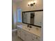 Bathroom featuring white cabinets, countertop, framed mirror, and glass shower at 558 Pendleton Dr, Moncks Corner, SC 29461