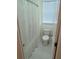 Cozy bathroom featuring a toilet, shower with a window, and light tile flooring at 558 Pendleton Dr, Moncks Corner, SC 29461