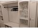 Detail of walk-in closet's custom white shelves with floral-themed wallpaper behind at 558 Pendleton Dr, Moncks Corner, SC 29461