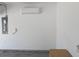 Garage wall with electric panel, a wall-mounted air conditioner, and electrical sockets at 558 Pendleton Dr, Moncks Corner, SC 29461