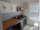 Functional laundry room with modern washer and dryer, wooden countertop, and patterned accent wall at 558 Pendleton Dr, Moncks Corner, SC 29461