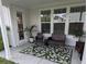 This covered patio offers a cozy seating area and is decorated with potted plants and a leaf-patterned rug at 558 Pendleton Dr, Moncks Corner, SC 29461