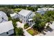 An aerial view of a three-story home with lush surroundings and neighboring homes in the distance at 566 Wading Pl, Daniel Island, SC 29492