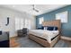 Stylish bedroom with blue accent wall, large windows, desk, and comfortable bedding at 566 Wading Pl, Daniel Island, SC 29492