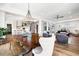 Open concept dining area with views into the living room and kitchen with hardwood floors and modern chandelier at 566 Wading Pl, Daniel Island, SC 29492