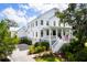 Beautiful two-story white home with an inviting front porch, lush landscaping, and a spacious driveway at 566 Wading Pl, Daniel Island, SC 29492