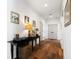 Hallway with hardwood floors, console table, and art, leading to neutral-toned doors at 566 Wading Pl, Daniel Island, SC 29492
