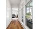 Hallway with hardwood floors and windows, leading to a bedroom with neutral decor at 566 Wading Pl, Daniel Island, SC 29492