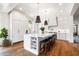 Bright kitchen featuring white cabinetry, a large center island with bar seating, and hardwood floors at 566 Wading Pl, Daniel Island, SC 29492