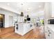 Open-concept kitchen with white cabinets, a center island, and seamless flow to the dining and living spaces at 566 Wading Pl, Daniel Island, SC 29492