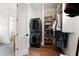 Convenient laundry room with stacked washer and dryer and built-in shelving at 566 Wading Pl, Daniel Island, SC 29492