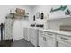 Well-organized laundry room with modern washer/dryer, marble countertop, cabinetry, and stylish decor at 566 Wading Pl, Daniel Island, SC 29492