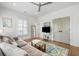 Relaxing living room with sectional sofa, shutters, wood floors, and a neutral rug at 566 Wading Pl, Daniel Island, SC 29492