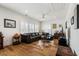 Comfortable living room with large sofa, hardwood floors, shutters, and ample natural light at 566 Wading Pl, Daniel Island, SC 29492