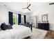 Bright main bedroom featuring hardwood floors, blue curtains, and large windows offering scenic views at 566 Wading Pl, Daniel Island, SC 29492
