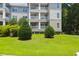 Well-maintained apartment building exterior with manicured green lawn and mature trees under a clear blue sky at 700 Daniel Ellis Dr # 3108, Charleston, SC 29412