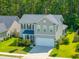 View of the home's exterior featuring a two-car garage, tidy landscaping, and a charming covered entry at 704 Kilarney Rd, Summerville, SC 29483