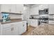 White kitchen with granite countertops, stainless steel appliances, and ample cabinet space at 704 Kilarney Rd, Summerville, SC 29483