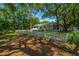 The backyard offers a serene setting with mature trees, a white picket fence, and a view of the home's exterior features at 734 Waterloo St, Charleston, SC 29412