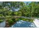 This backyard has a deck, lush greenery, and a white picket fence, creating an ideal space for relaxation and entertaining at 734 Waterloo St, Charleston, SC 29412