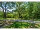 A well-maintained backyard with a white picket fence, mature trees, and vibrant green grass, perfect for outdoor enjoyment at 734 Waterloo St, Charleston, SC 29412