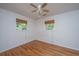 A bright bedroom is filled with hardwood floors, a ceiling fan, and natural light from two windows at 734 Waterloo St, Charleston, SC 29412