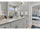 Modern bathroom with double vanity, granite countertops, and a large mirror reflecting natural light and bedroom at 753 Blue Iris Way, Summerville, SC 29486