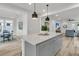 Open concept features a gray kitchen island with quartz countertops, pendant lighting, and dining area at 753 Blue Iris Way, Summerville, SC 29486