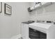 Functional laundry area equipped with a modern washer and dryer set, complemented by overhead storage shelving at 753 Blue Iris Way, Summerville, SC 29486