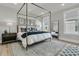 Bright main bedroom featuring a four-poster bed, stylish decor, and plenty of natural light at 753 Blue Iris Way, Summerville, SC 29486