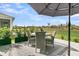Cozy outdoor dining area on the patio with seating for four under shade with community view at 753 Blue Iris Way, Summerville, SC 29486