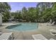 Community pool featuring lounge chairs, umbrellas, and refreshing clear water surrounded by lush landscaping at 8059 Shadow Oak Dr, North Charleston, SC 29406